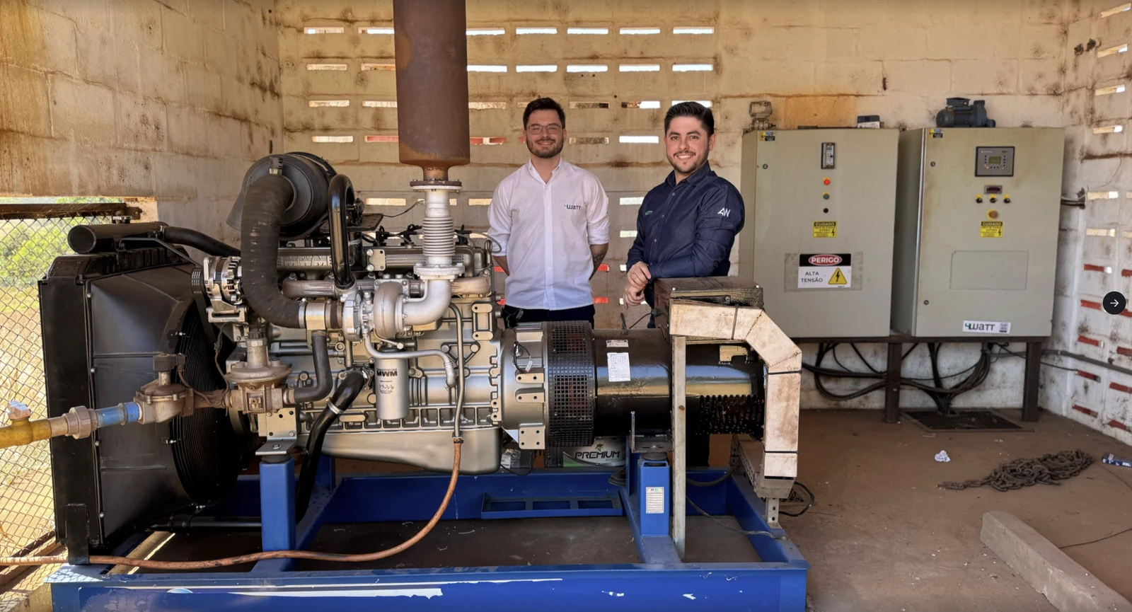Equipe em campo ao lado de um motogerador a biogás e dos painéis elétricos